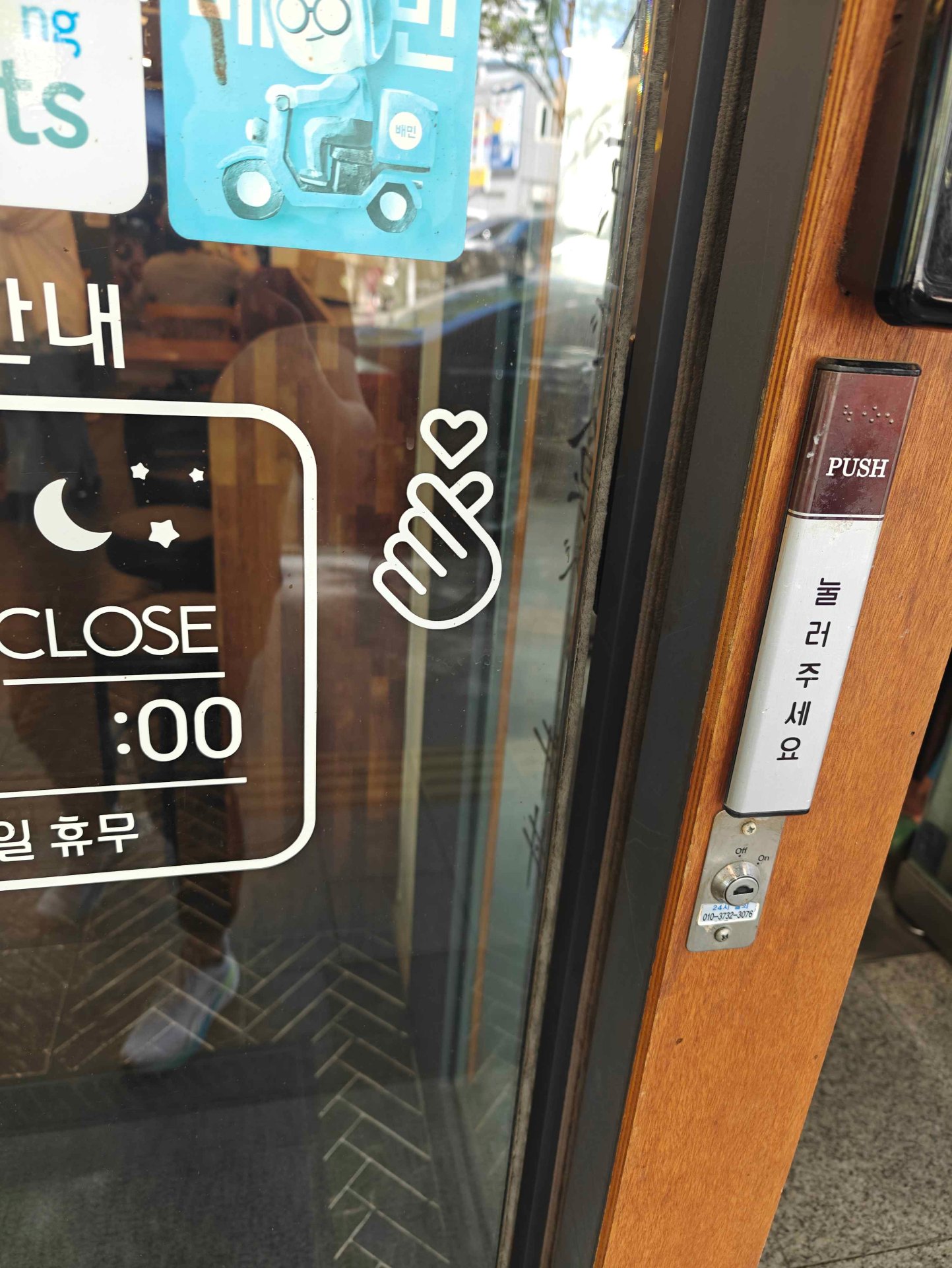 Koreansk finger heart-dekal på caféfönster