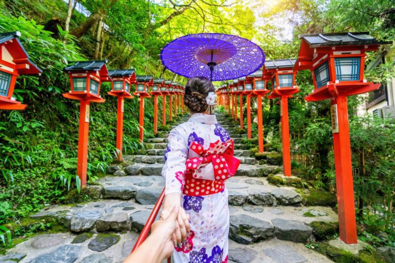 Kvinna i traditionell kimono med rött paraply