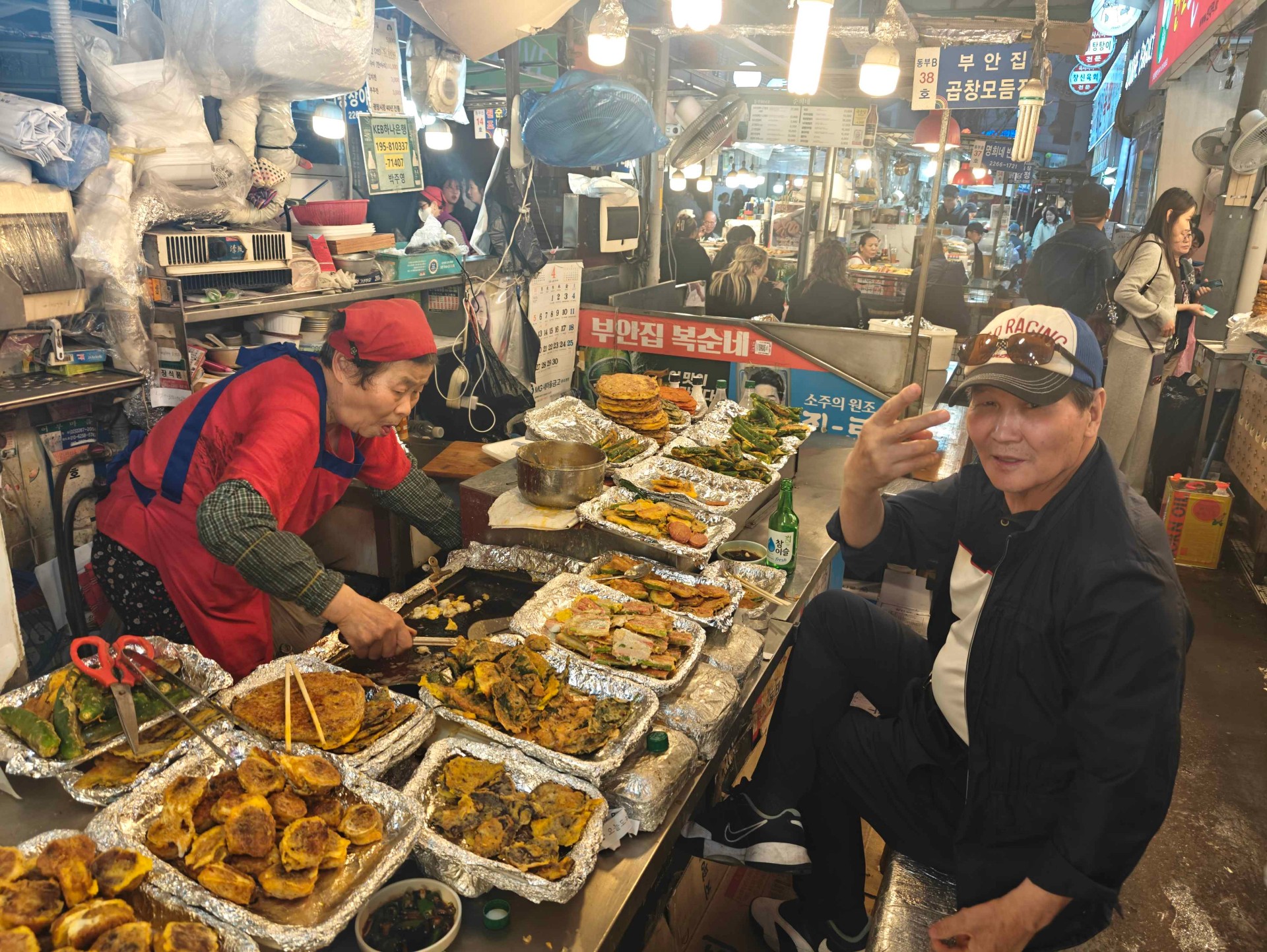 Lokal kock som lagar koreanska pannkakor på matmarknad