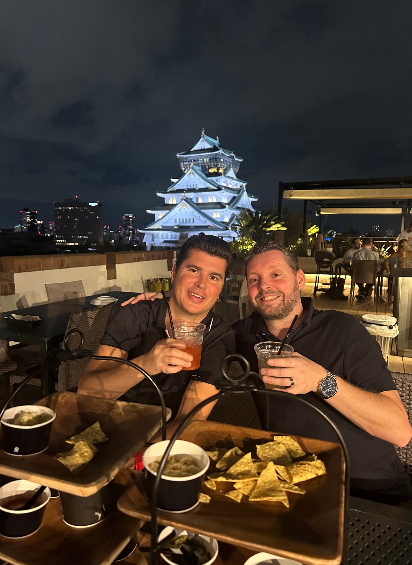 Vänner med drinkar vid Osaka slott